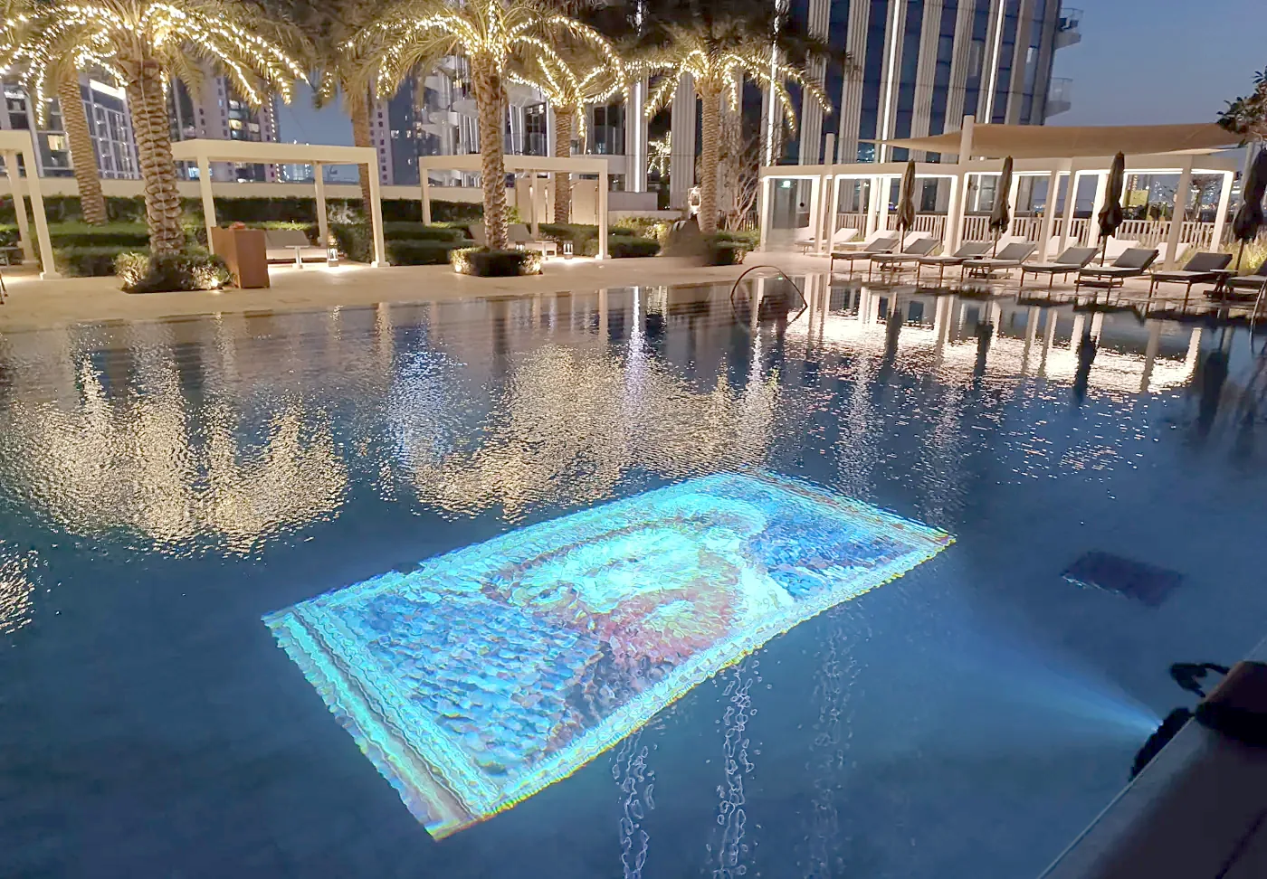 A Van Gogh painting projected into a hotel pool at night